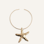 Structured gold choker necklace with large starfish pendant.