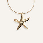 Structured gold choker necklace with large starfish pendant.
