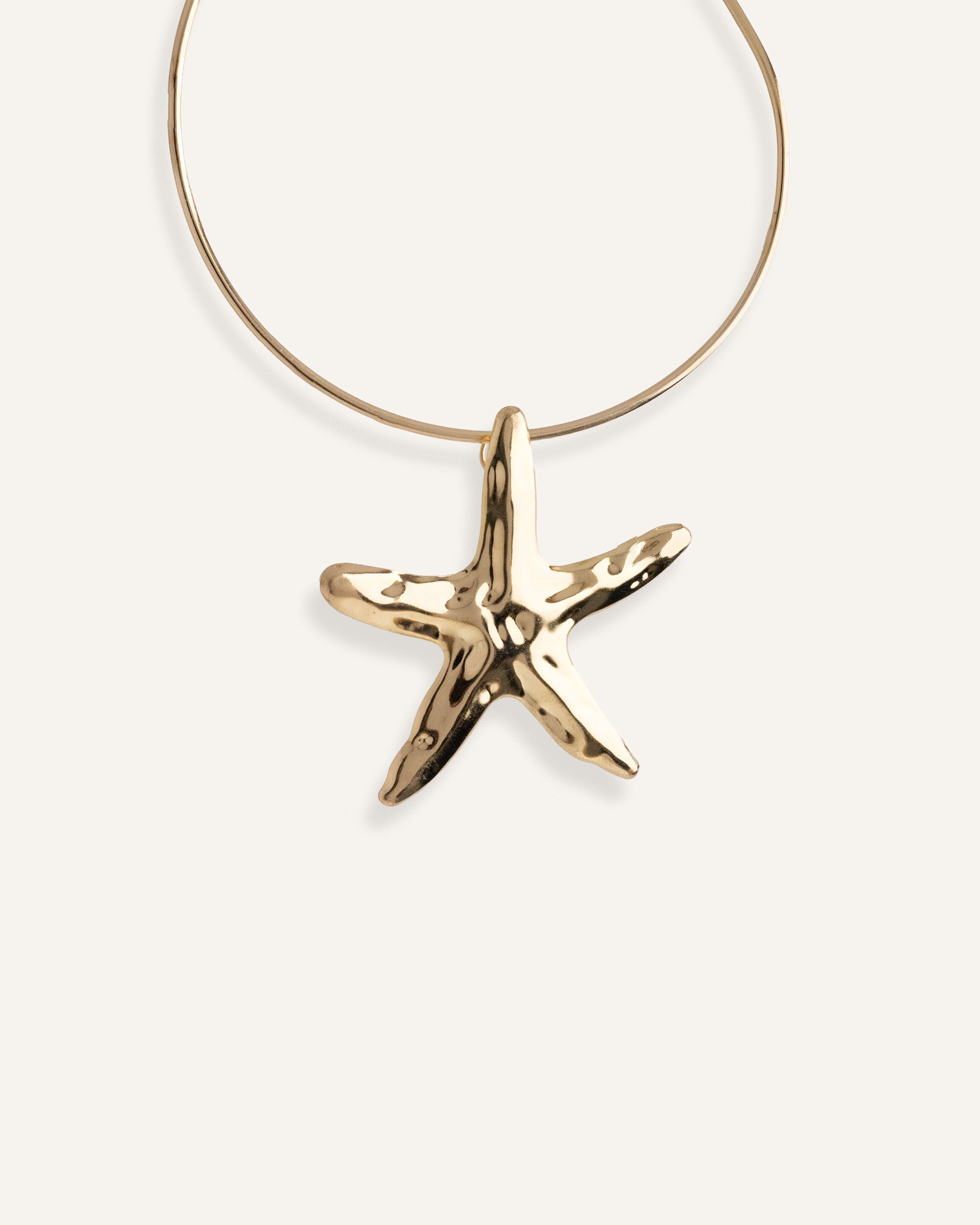 Structured gold choker necklace with large starfish pendant.
