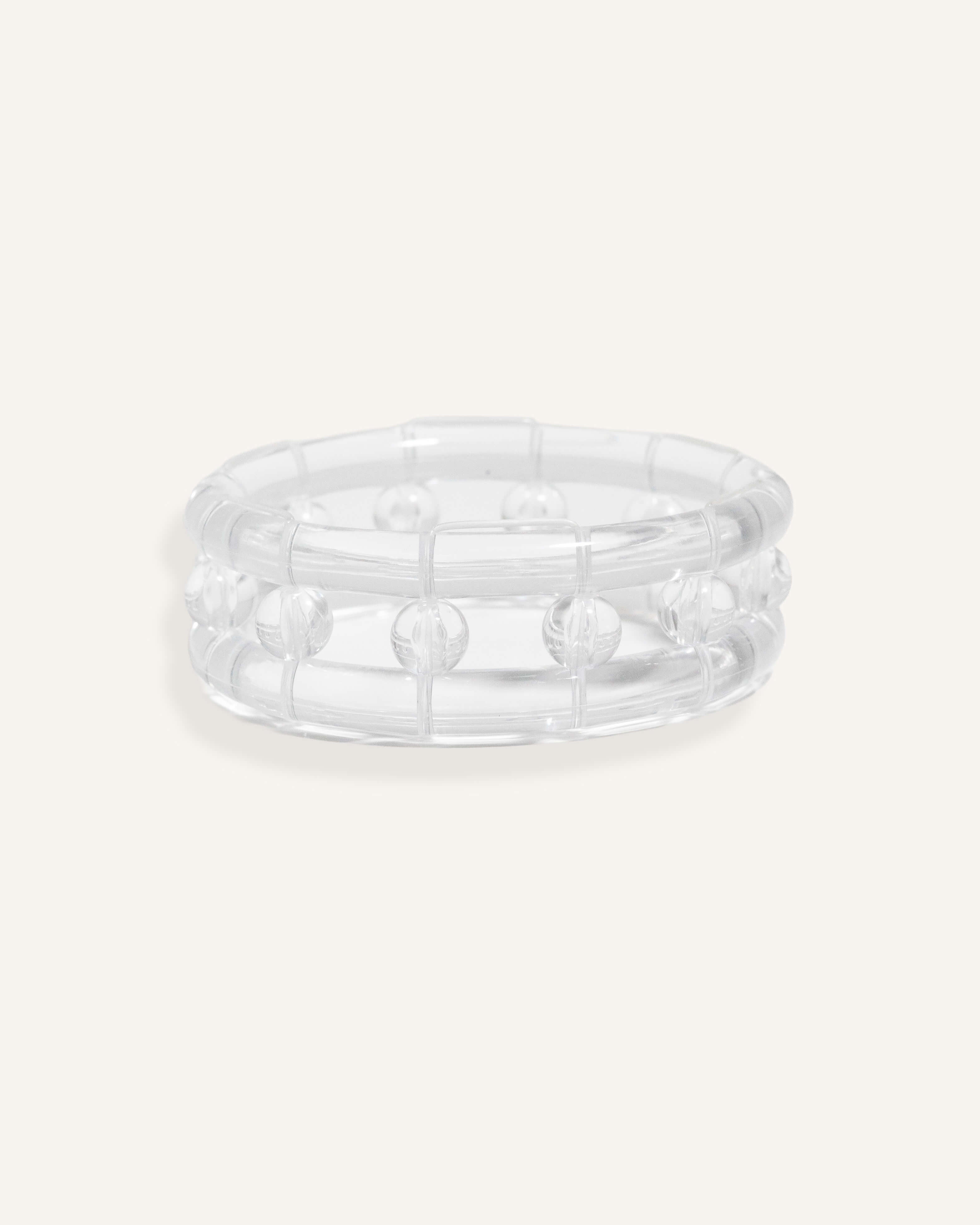 Clear resin bracelet with raised bubbles and a rounded form.
