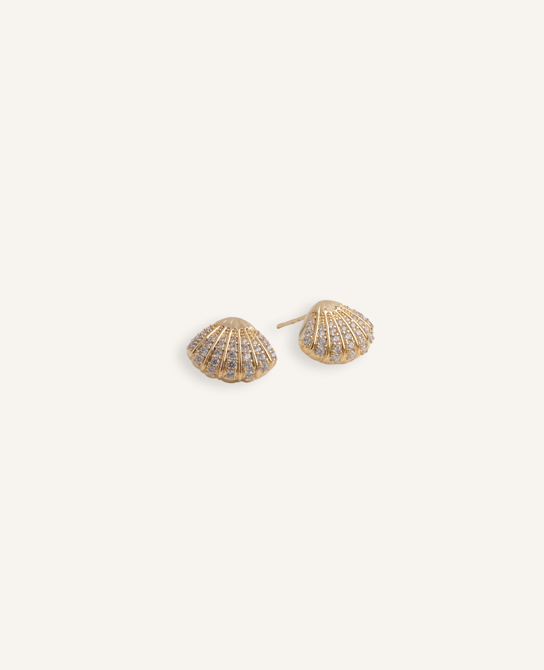 Gold plated shell stud earrings with rows of clear crystals.
