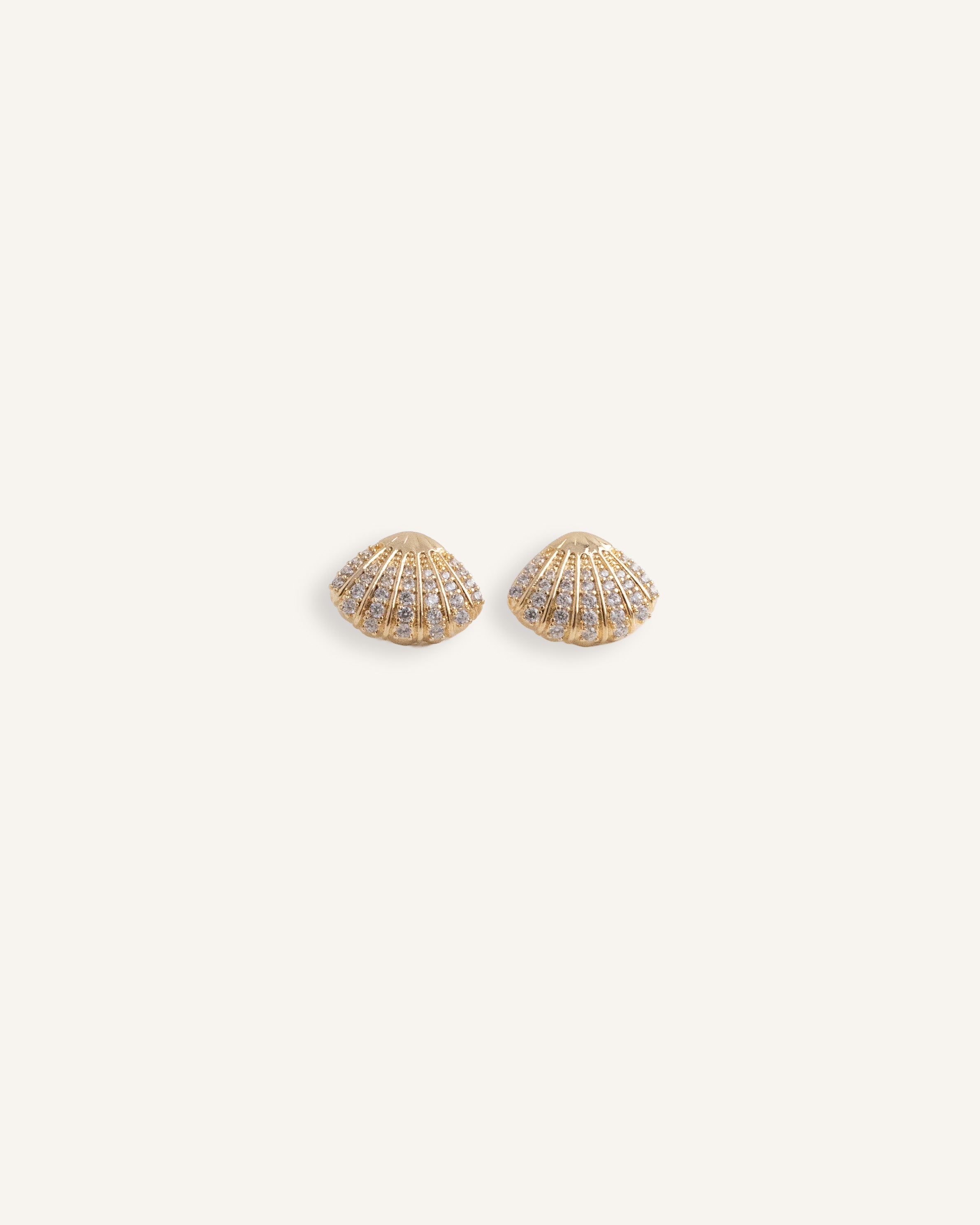 Gold plated shell stud earrings with rows of clear crystals.
