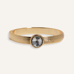  Gold cuff bracelet with ridged band and clear round gemstone at center