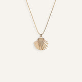 Minimal gold necklace with shell-shaped pendant.
