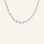 White disc bead necklace with gold drops, styled for a clean summer look.
