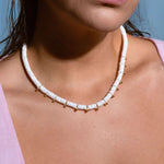 Model wearing white heishi bead necklace with gold accents, stylish boho summer jewelry look, perfect for beach outfits and vacations