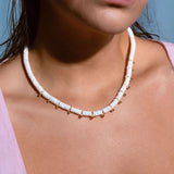 Model wearing white heishi bead necklace with gold accents, stylish boho summer jewelry look, perfect for beach outfits and vacations