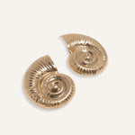 Bold shell earrings in gold and silver, styled for an ocean-inspired summer collection.