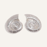 Bold shell earrings in gold and silver, styled for an ocean-inspired summer collection.