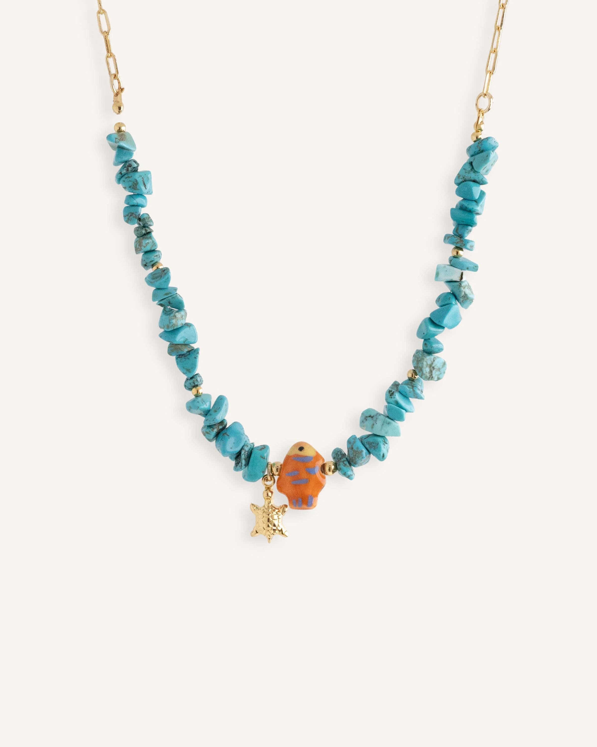 Turquoise chip necklaces with colorful ceramic fish beads and small gold star charms, in orange and blue variations.