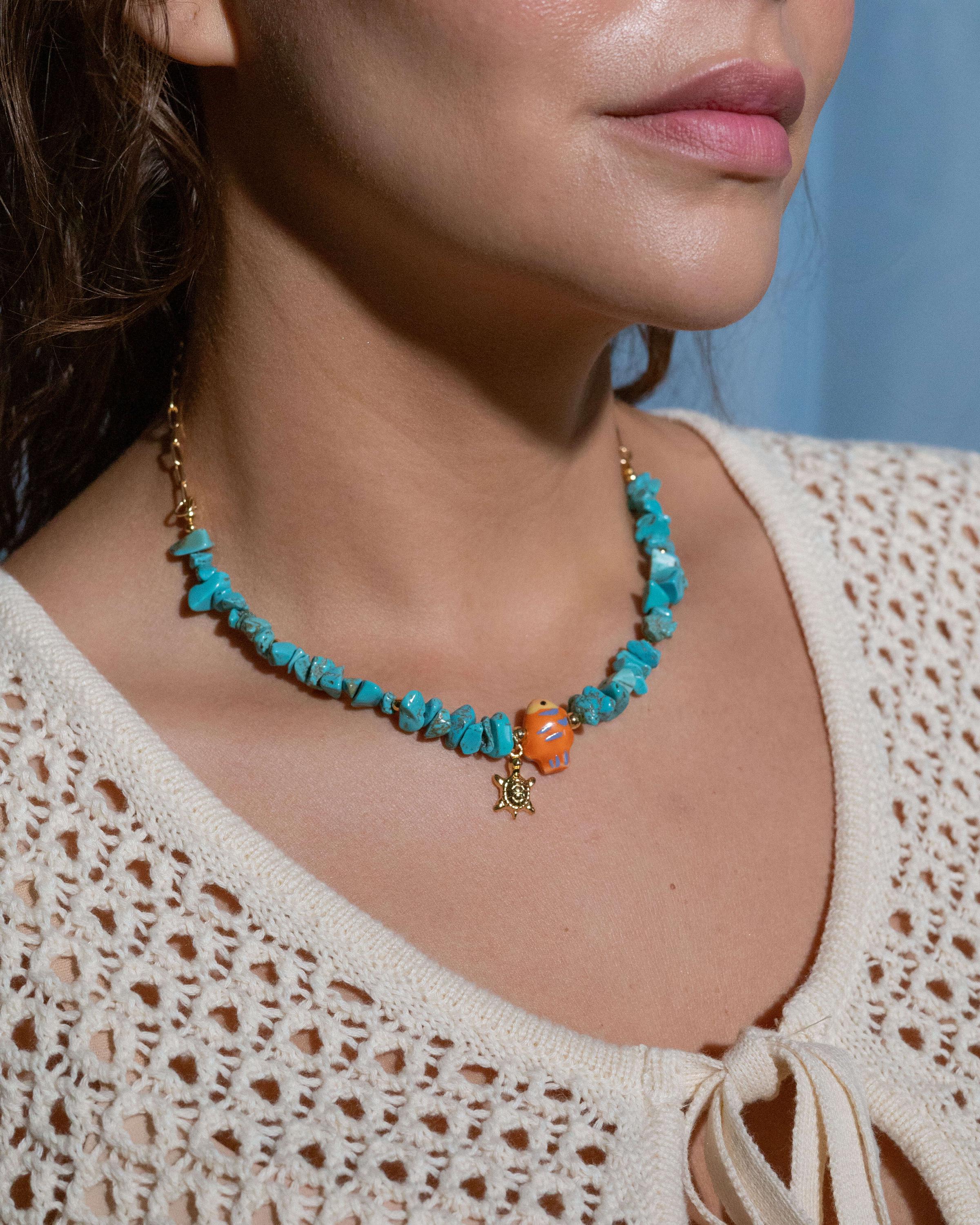 Turquoise gemstone chip necklace with orange ceramic fish charm and gold starfish pendant, 14k gold filled chain, playful ocean-inspired beach jewelry
