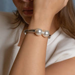 rhodium plated double pearl bracelet with two white pearls, sleek silver-tone minimalist bangle for elegant everyday wear