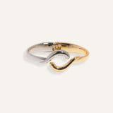 Two-tone bracelet in silver and gold with wave crossover design, styled for minimalist everyday wear.