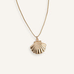 Minimal gold necklace with shell-shaped pendant.