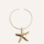 Structured gold choker necklace with large starfish pendant.