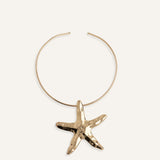Structured gold choker necklace with large starfish pendant.