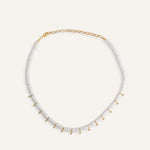 Close-up of white disc beads and gold charm details on minimalist beach necklace, modern handmade jewelry for layering, trendy gift idea