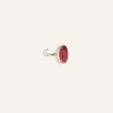 Gold adjustable ring with a red or blue stone, styled with a modern bold shape.
