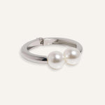 Hinged cuff bracelet with two pearl accents, shown in gold-plated and silver finishes.