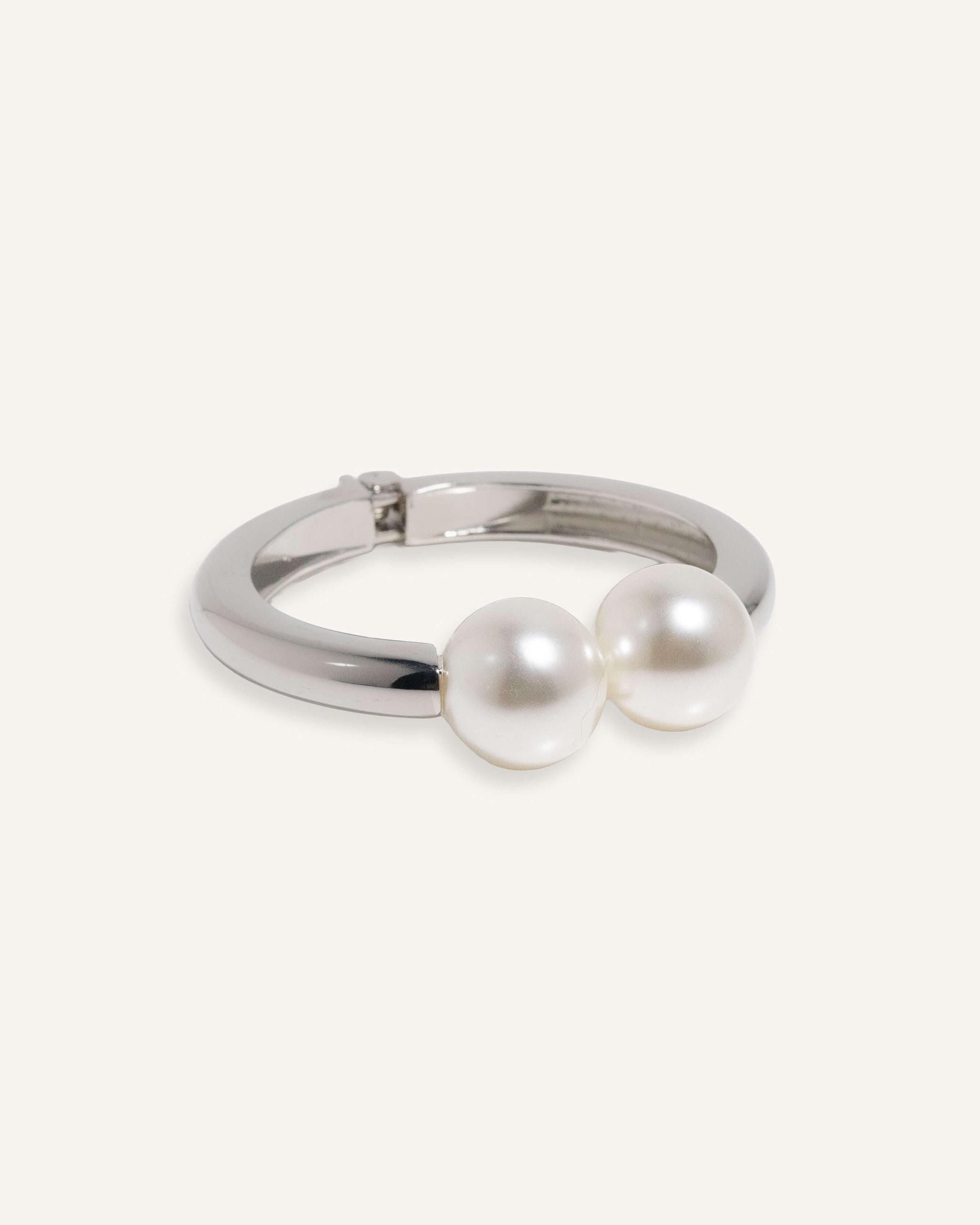 Hinged cuff bracelet with two pearl accents, shown in gold-plated and silver finishes.