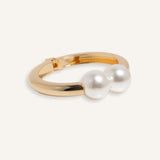 Hinged cuff bracelet with two pearl accents, shown in gold-plated and silver finishes