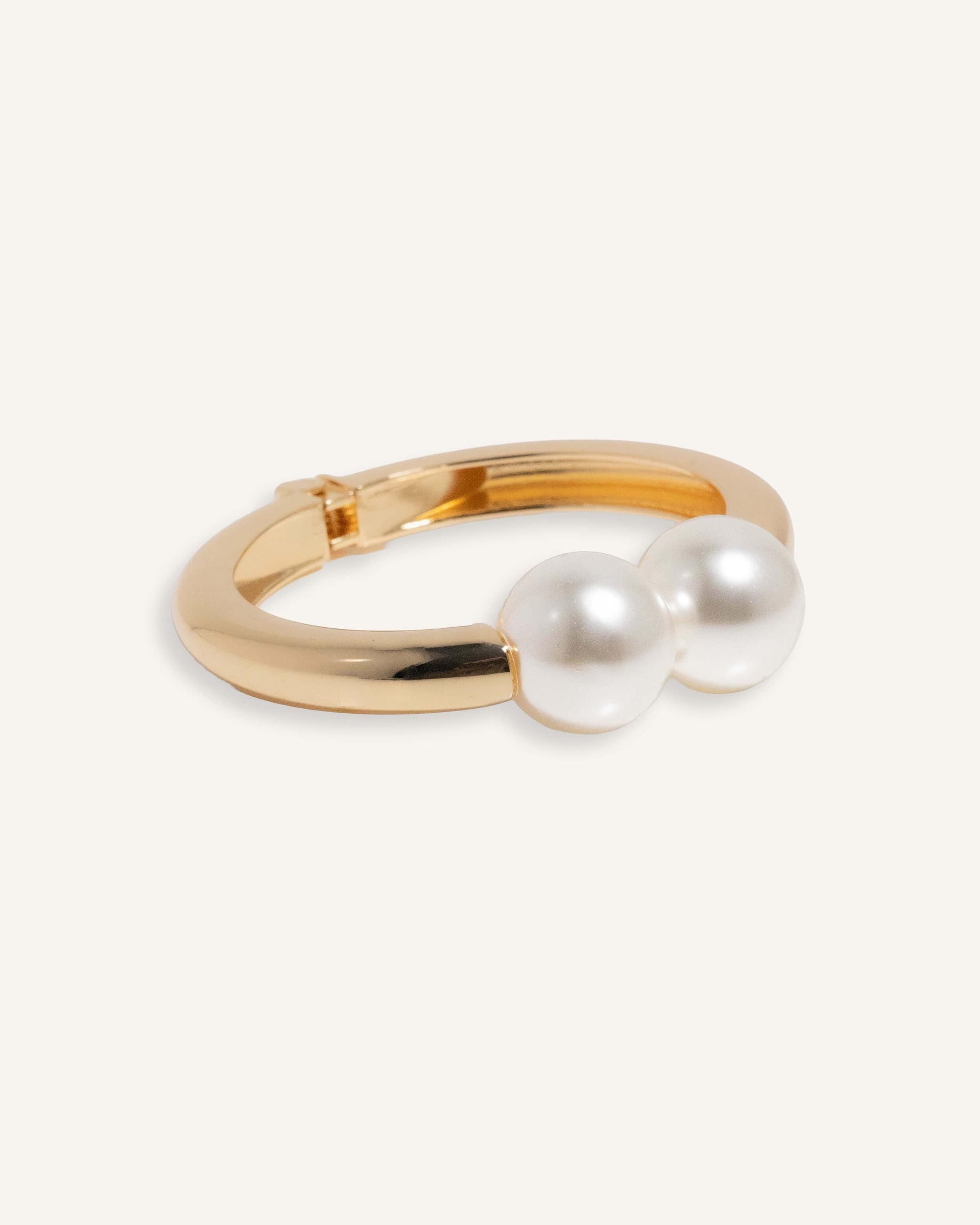 Hinged cuff bracelet with two pearl accents, shown in gold-plated and silver finishes