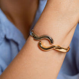 Two-tone wave bangle bracelet in gold-plated and rhodium finish with hinge closure – ocean-inspired cuff