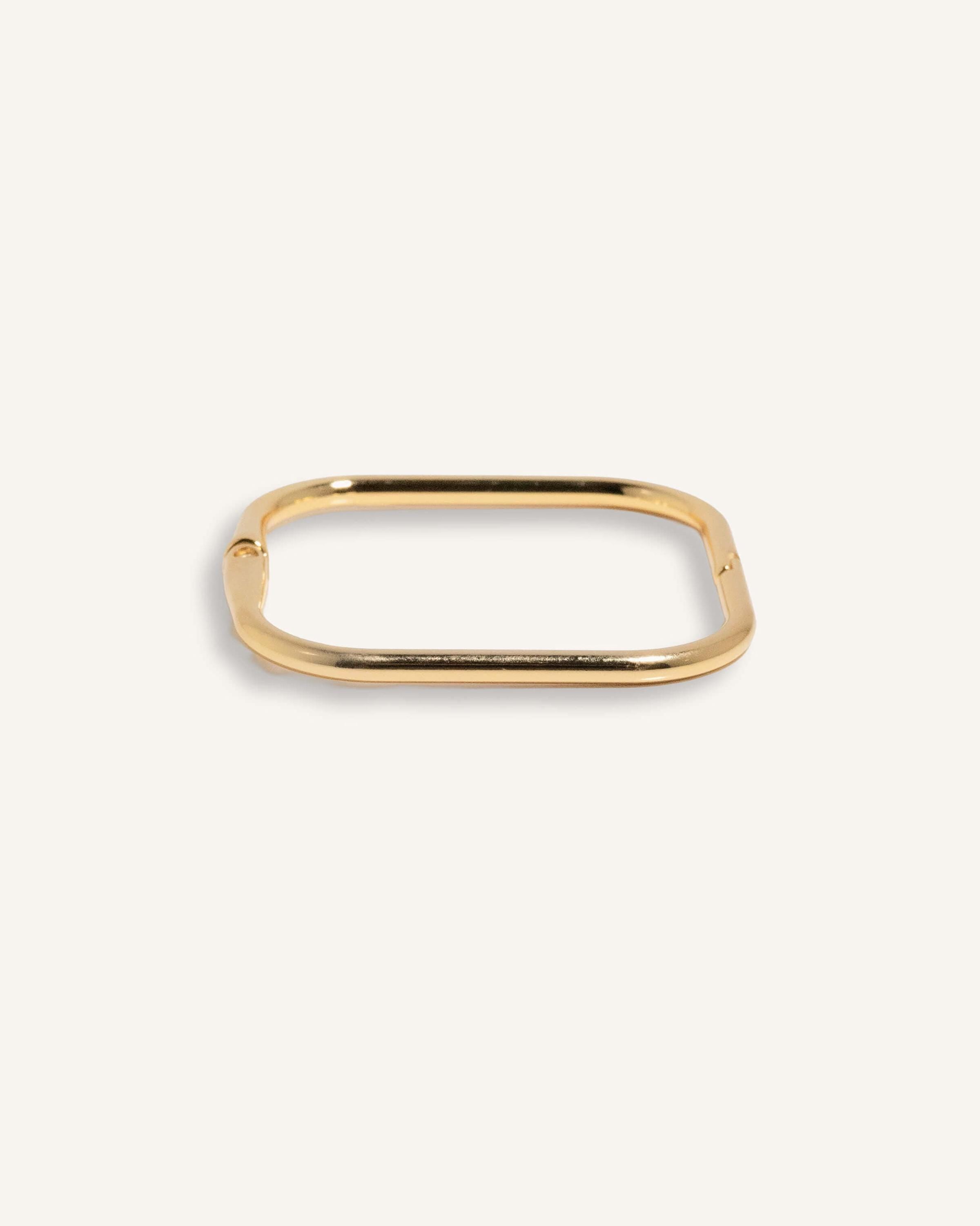 Gold-plated square edge bracelet with sleek finish, shown flat on neutral background.