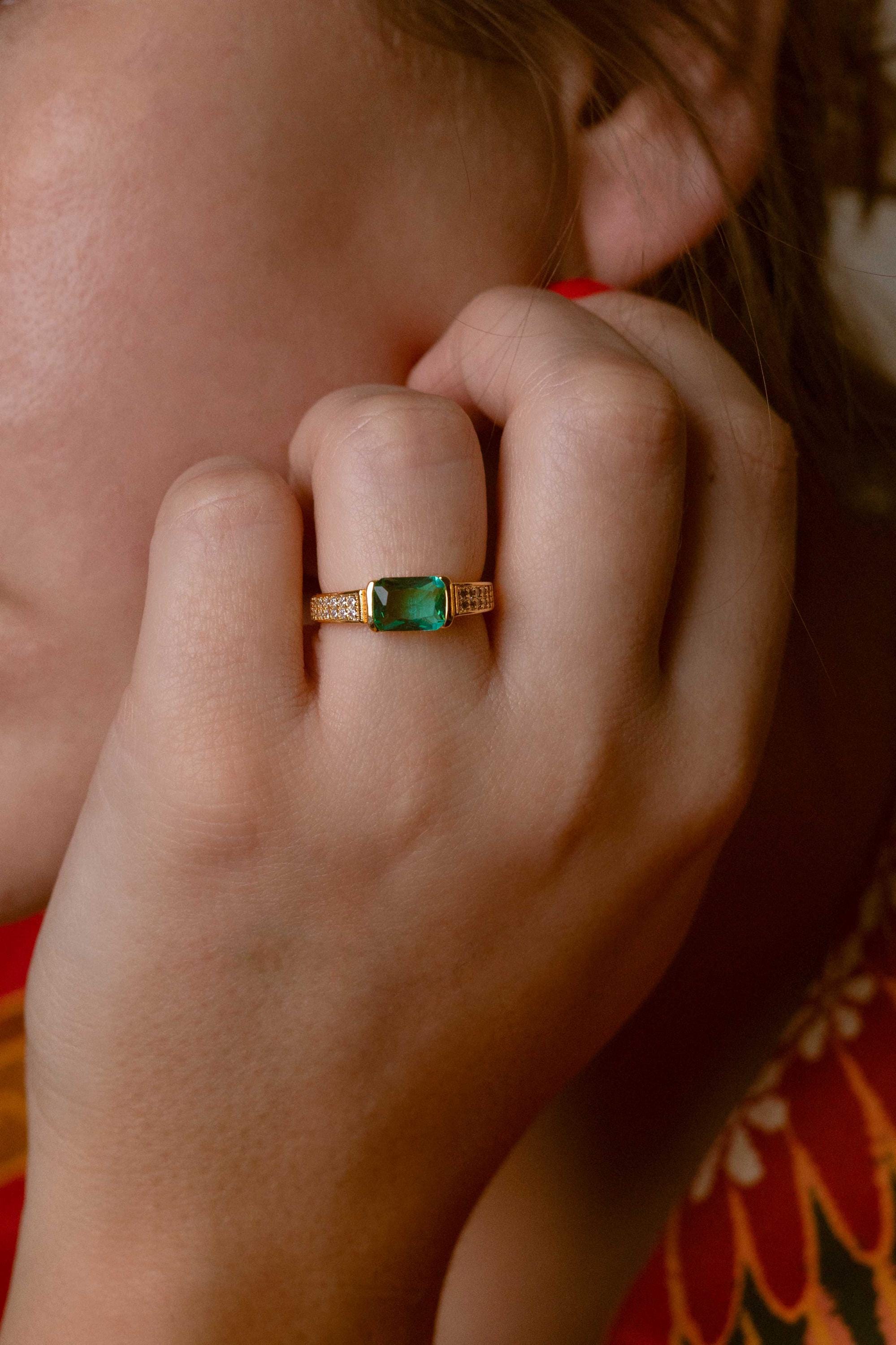 Elegant jade ring featuring a vibrant green stone and three zircon details