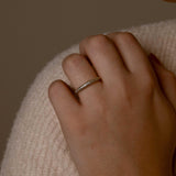 Close-up of silver rings with thick bands and zircon accents