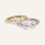  Hinged cuff bracelet with two pearl accents, shown in gold-plated and silver finishes.