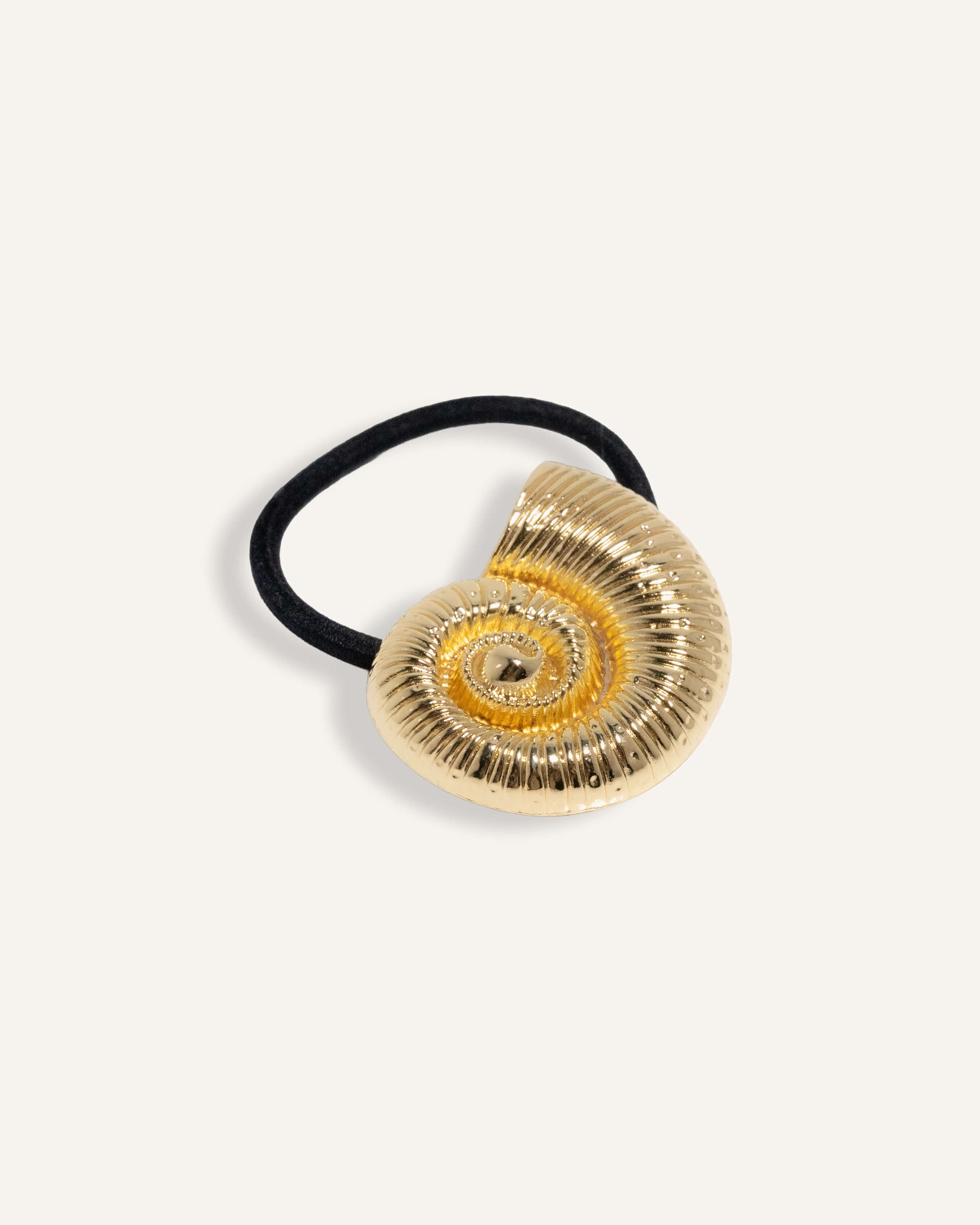 Hair tie with sculpted shell charm in gold and silver finish, attached to black elastic.

