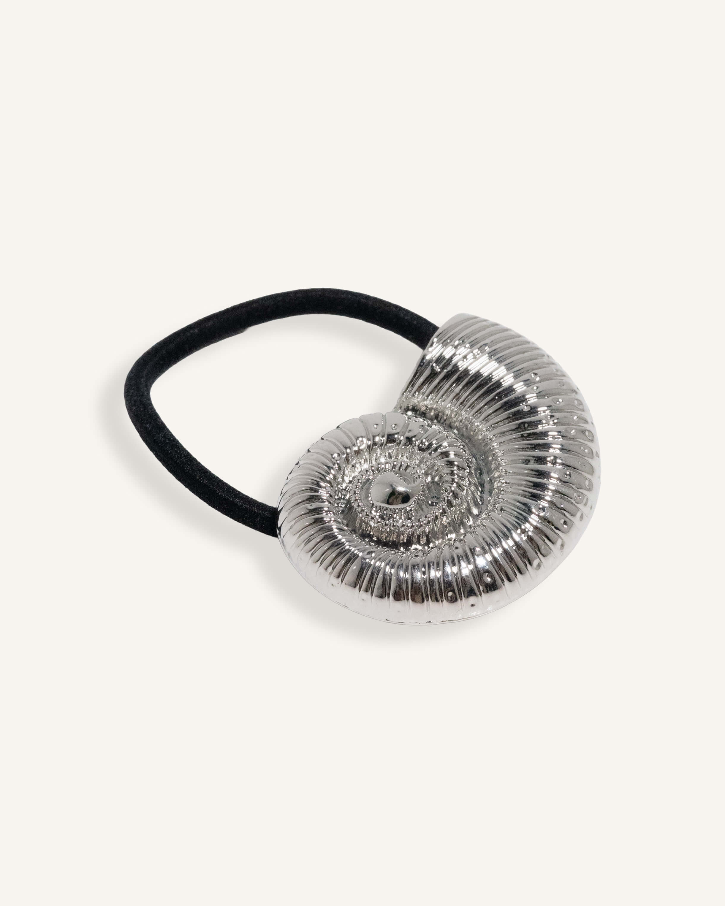 Hair tie with sculpted shell charm in gold and silver finish, attached to black elastic