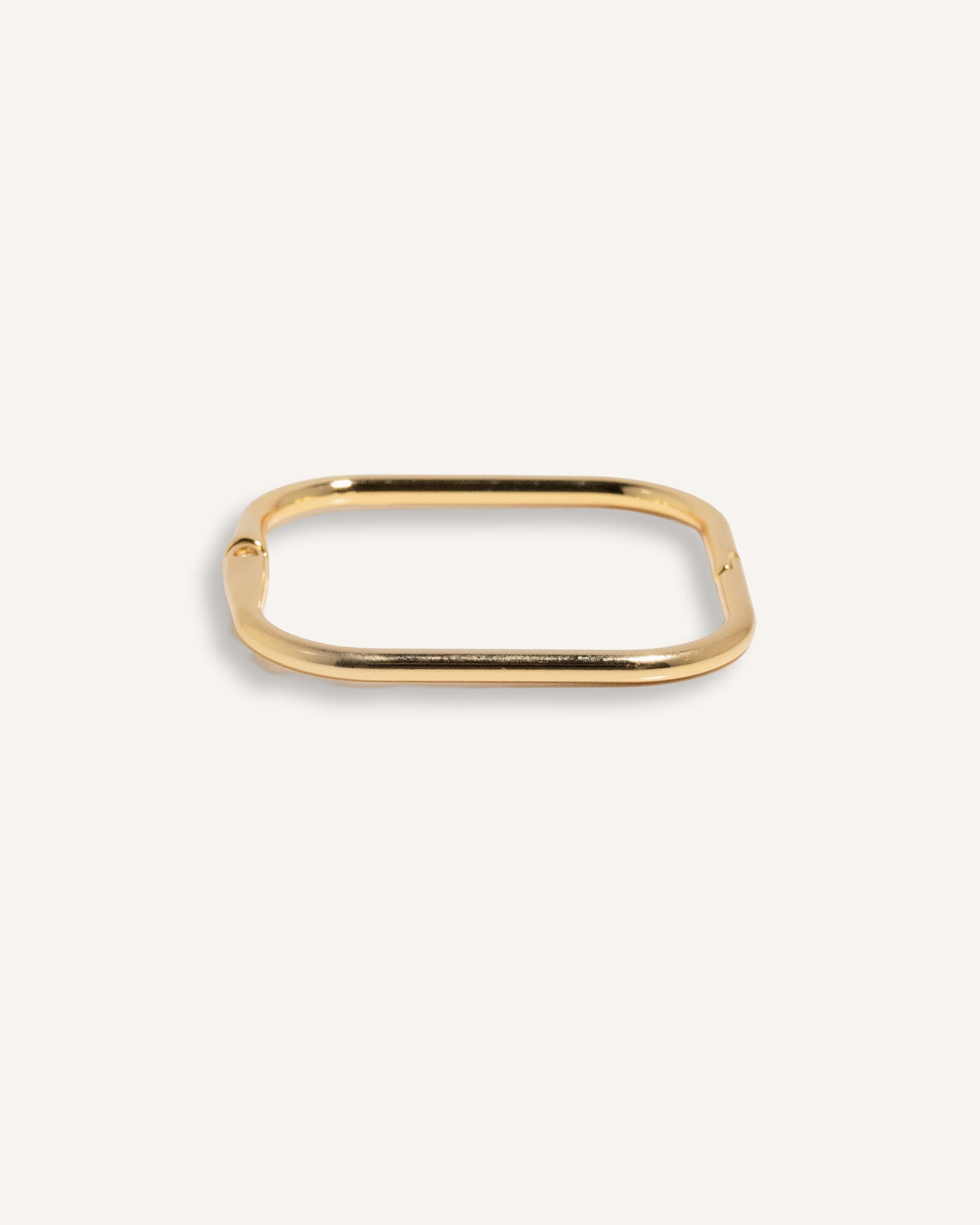 Gold-plated square edge bracelet with sleek finish, shown flat on neutral background.
