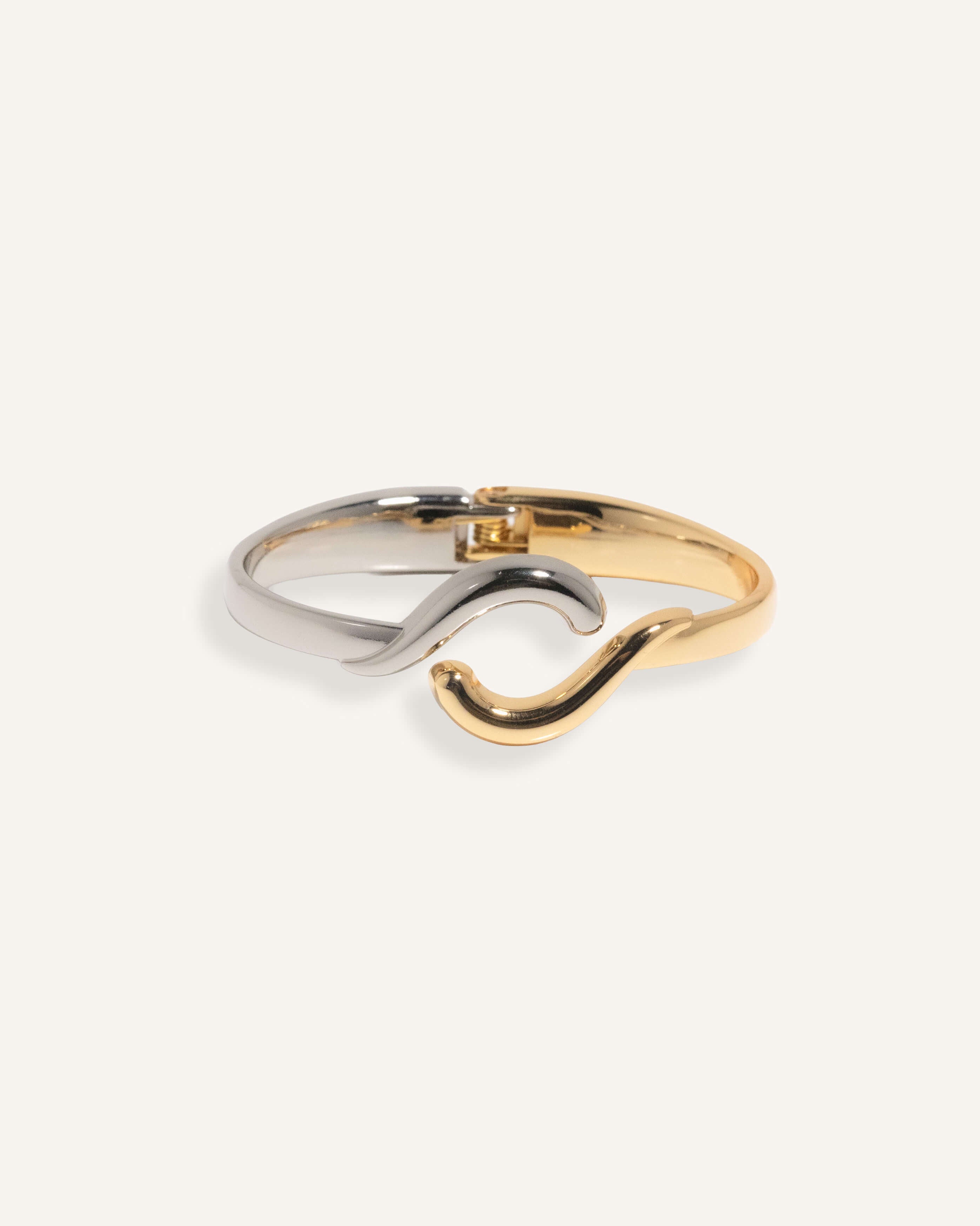 Two-tone bracelet in silver and gold with wave crossover design, styled for minimalist everyday wear.
