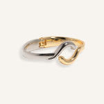 Two-tone bracelet in silver and gold with wave crossover design, styled for minimalist everyday wear