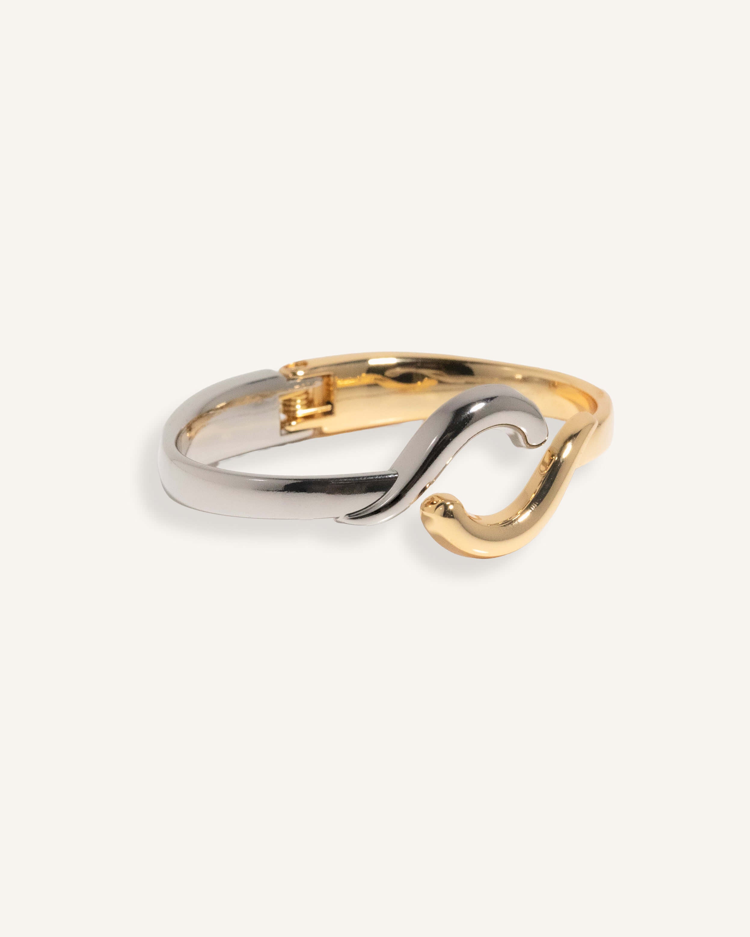 Two-tone bracelet in silver and gold with wave crossover design, styled for minimalist everyday wear