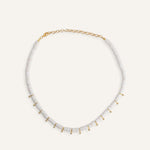  White disc bead necklace with gold drops, styled for a clean summer look.