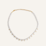  White disc bead necklace with gold drops, styled for a clean summer look.