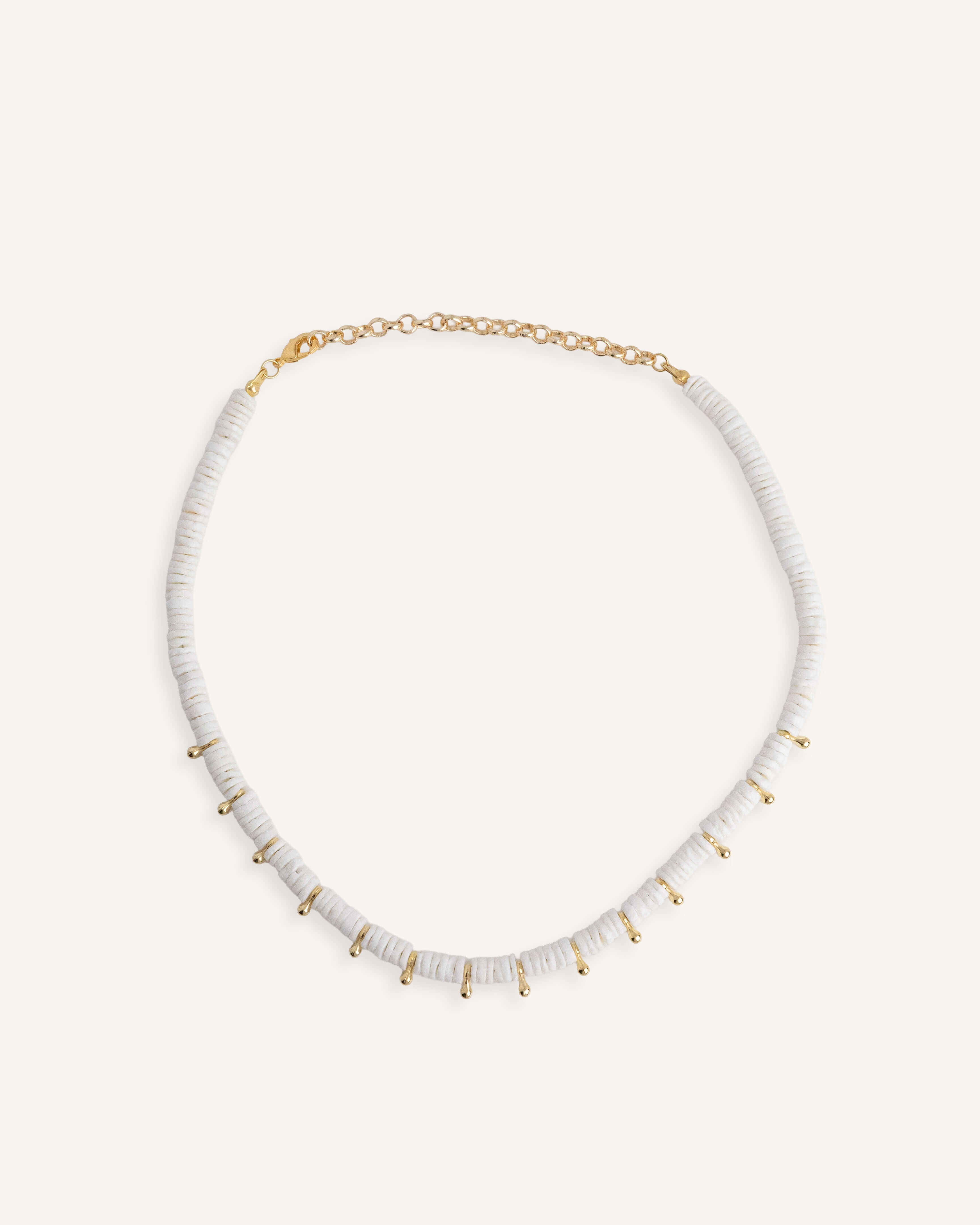  White disc bead necklace with gold drops, styled for a clean summer look.