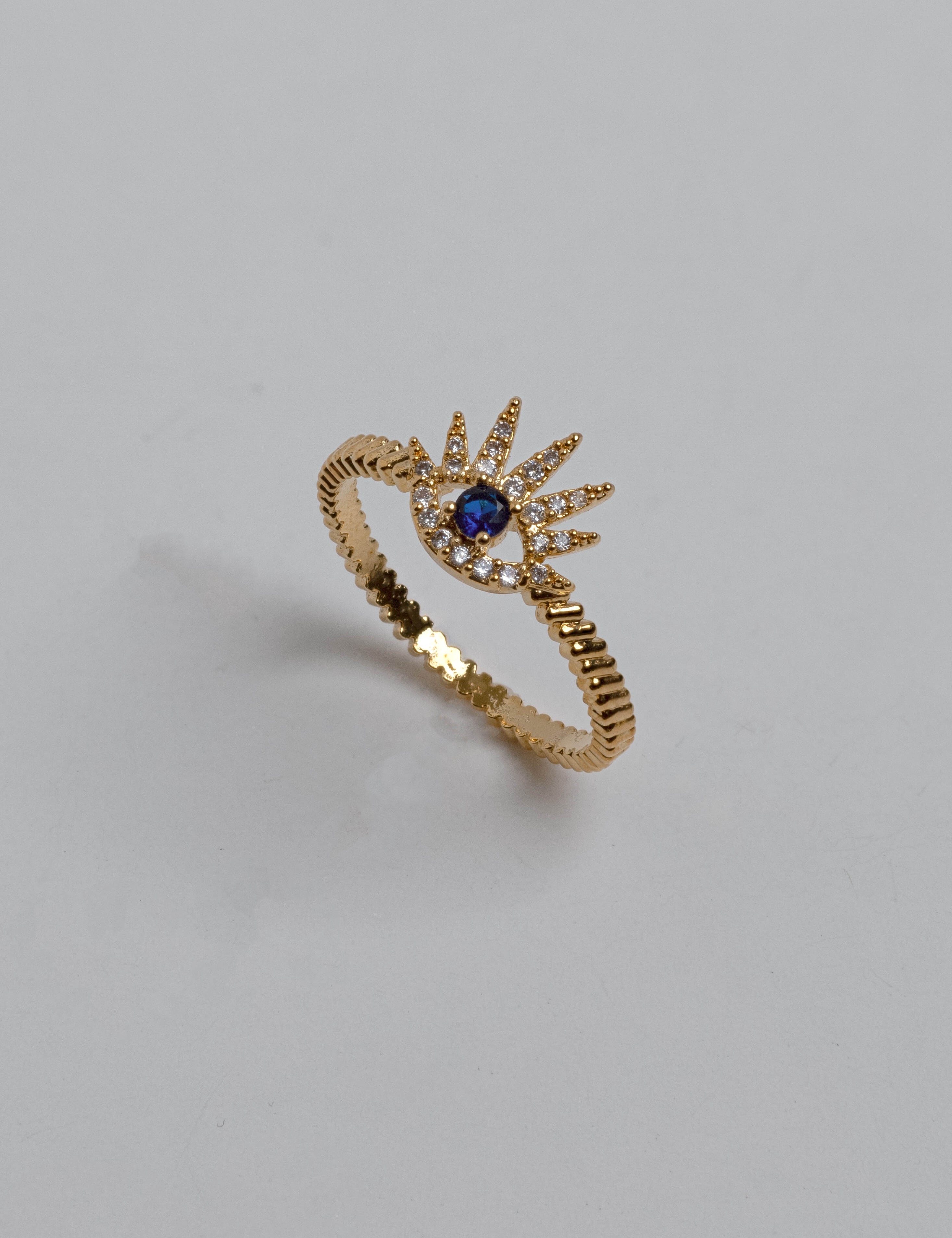 Close-up of gold evil eye ring with sparkling zircon stones