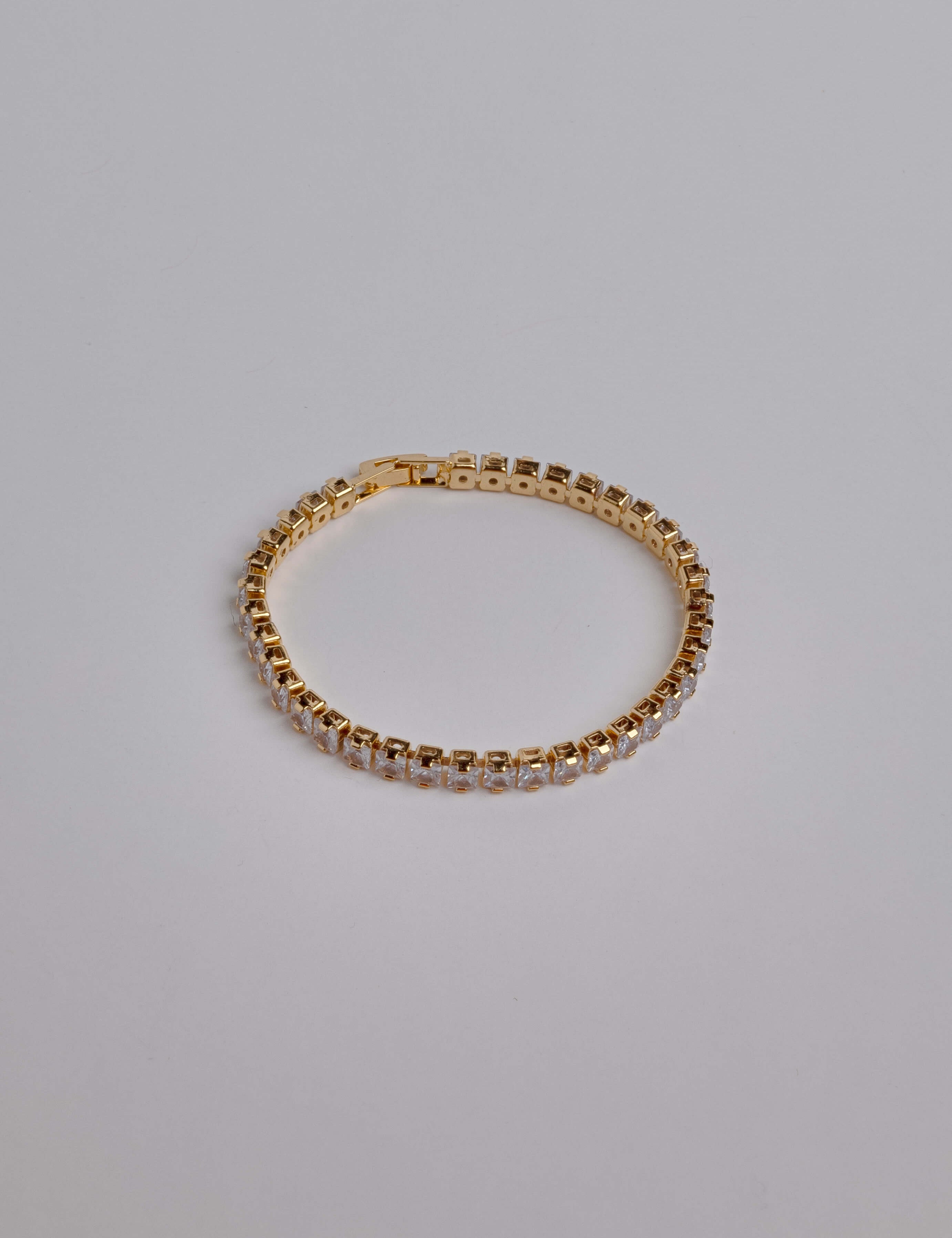 Square gold-dipped women's tennis bracelet with cubic zirconia stones, featuring a structured and refined design.