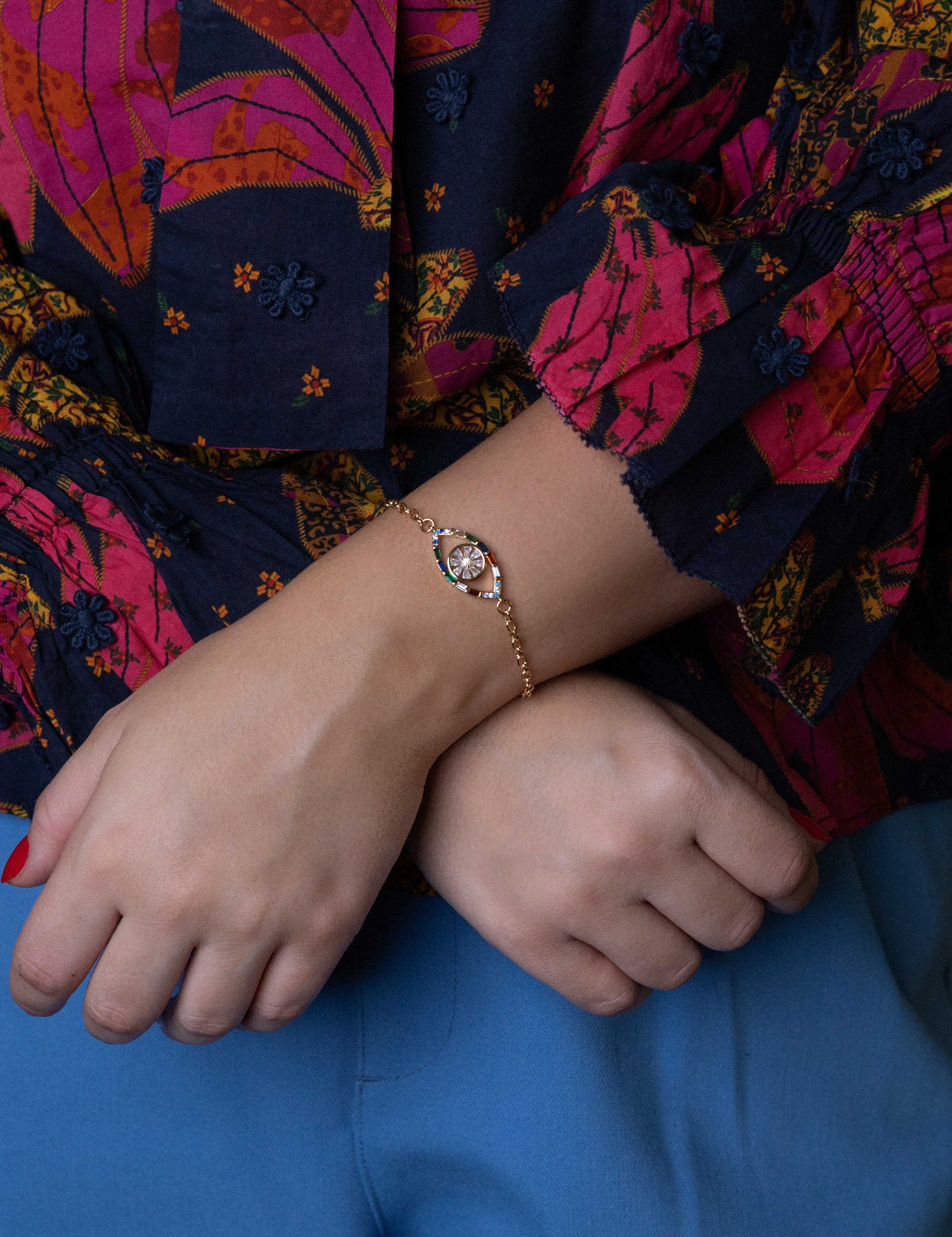 Gold evil eye bracelet with colorful gemstones and cubic zirconia charms, perfect for protection and stylish layering.