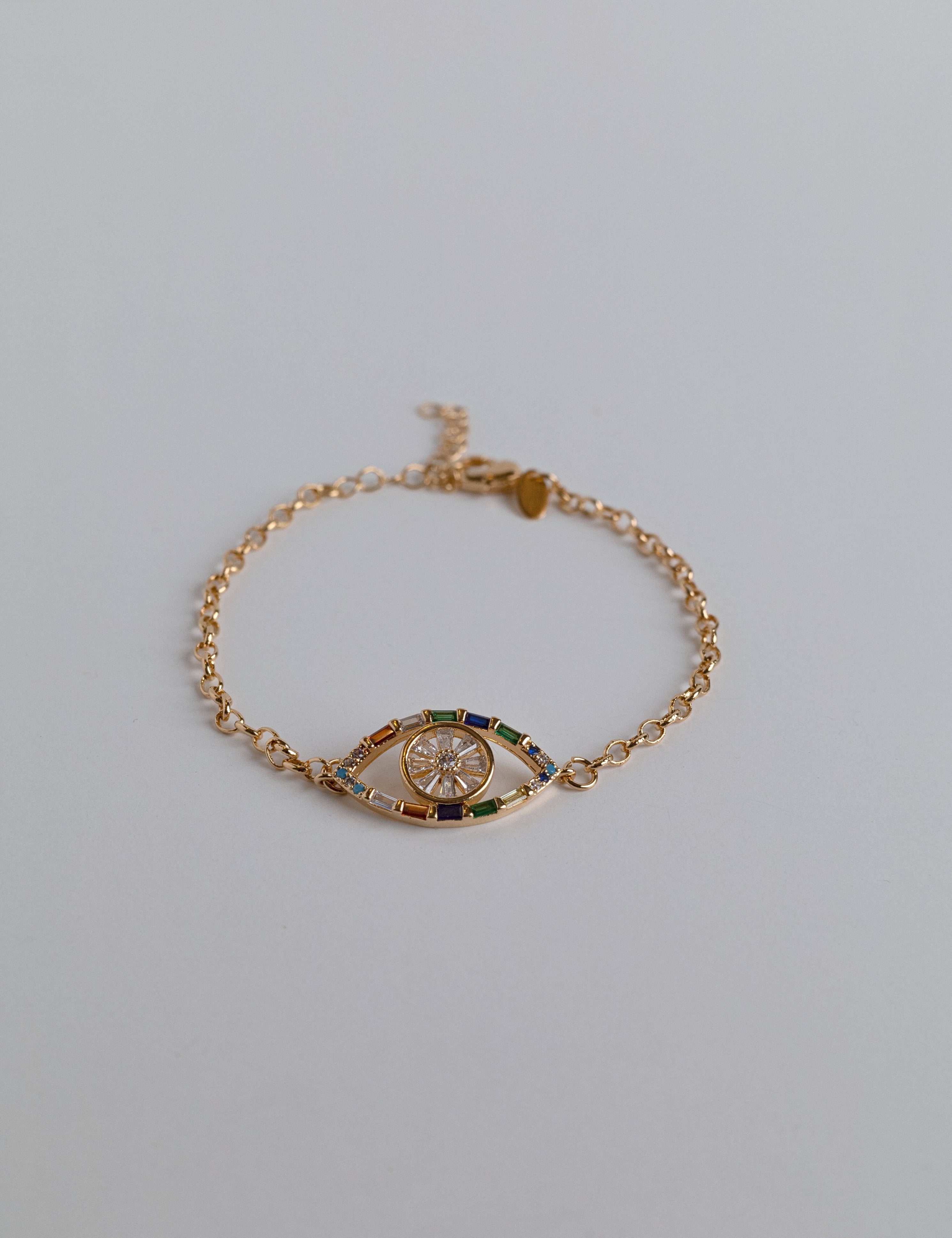 Gold evil eye bracelet with colorful gemstones and cubic zirconia charms, perfect for protection and stylish layering.