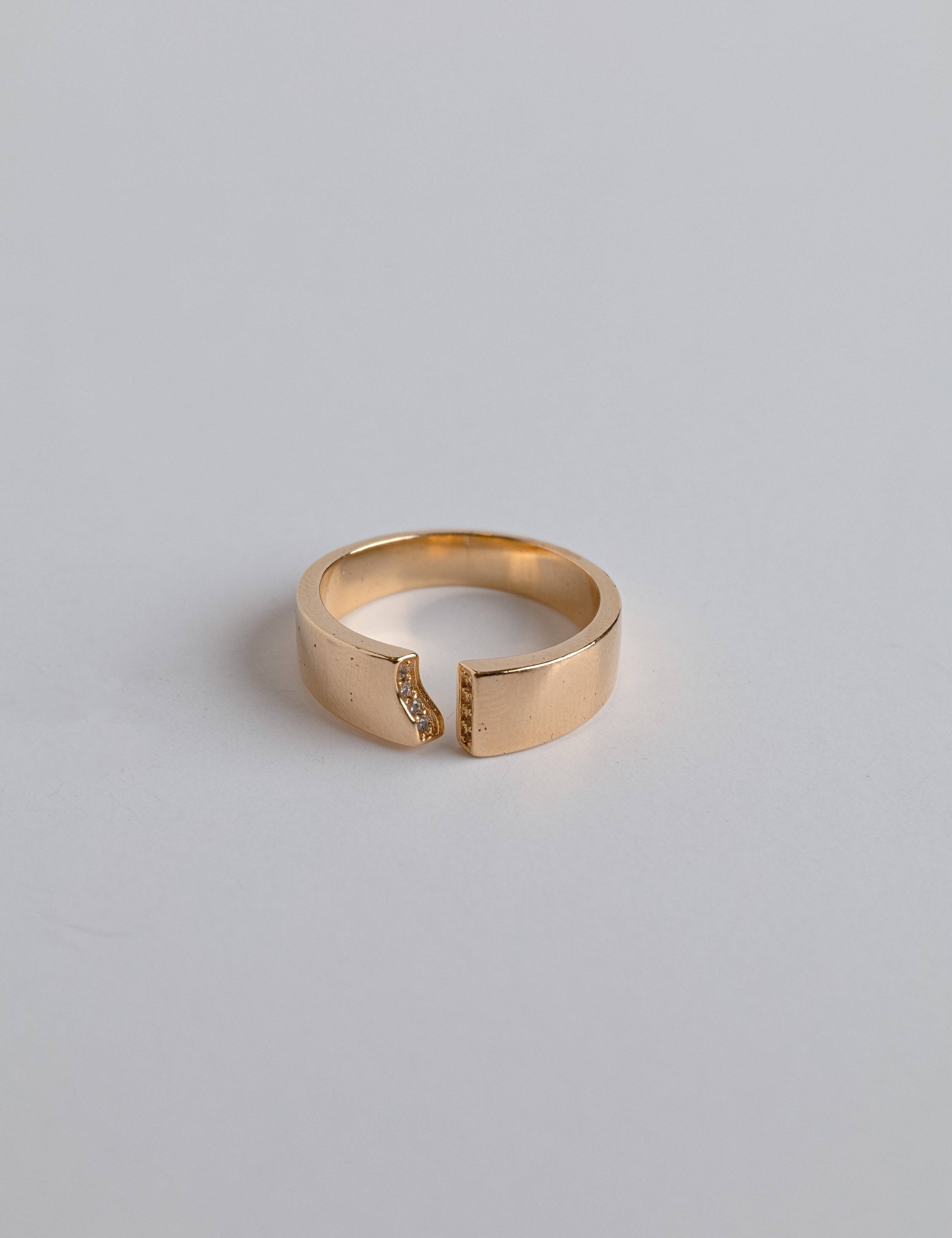 Close-up of a 14K gold ring with a bow-like elegance and zircon accents
