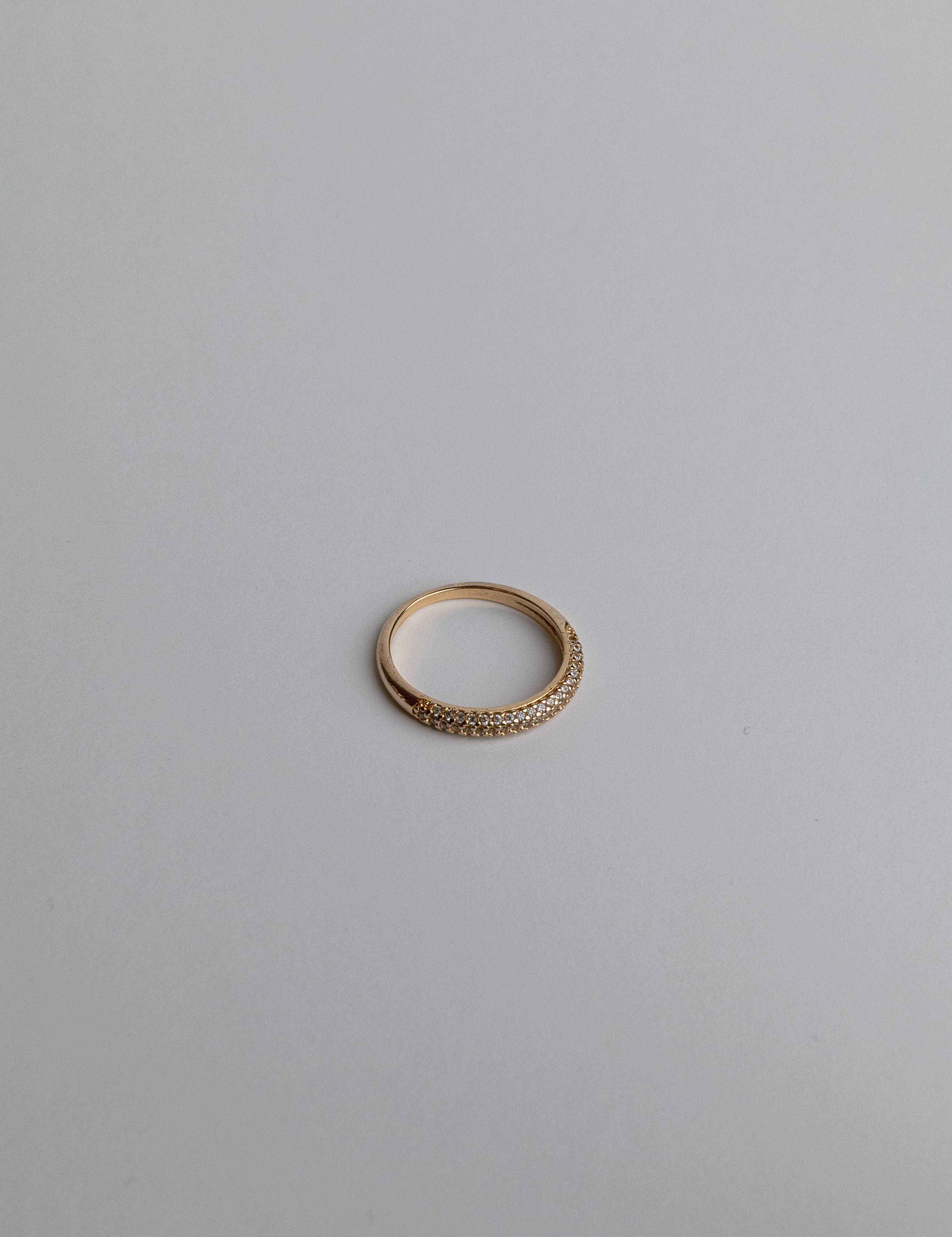 Close-up of chunky gold ring with thick bands and zircon accents